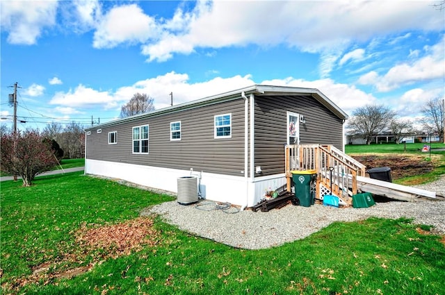 view of property exterior with central air condition unit and a yard