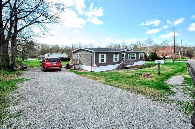 view of front facade with a front yard and gravel driveway