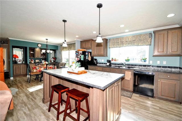 kitchen featuring a center island, ornamental molding, a sink, and black appliances