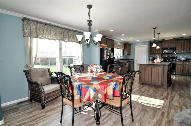 dining area with crown molding, baseboards, light wood-type flooring, recessed lighting, and a chandelier