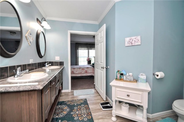 bathroom featuring a sink, ornamental molding, and wood finished floors