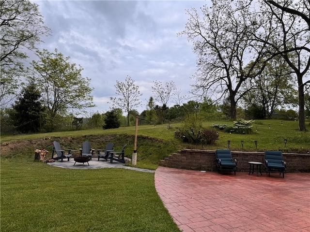 view of community featuring a yard, a fire pit, and a patio area