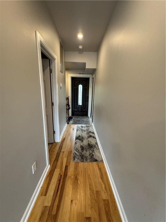 hallway featuring baseboards and light wood-type flooring