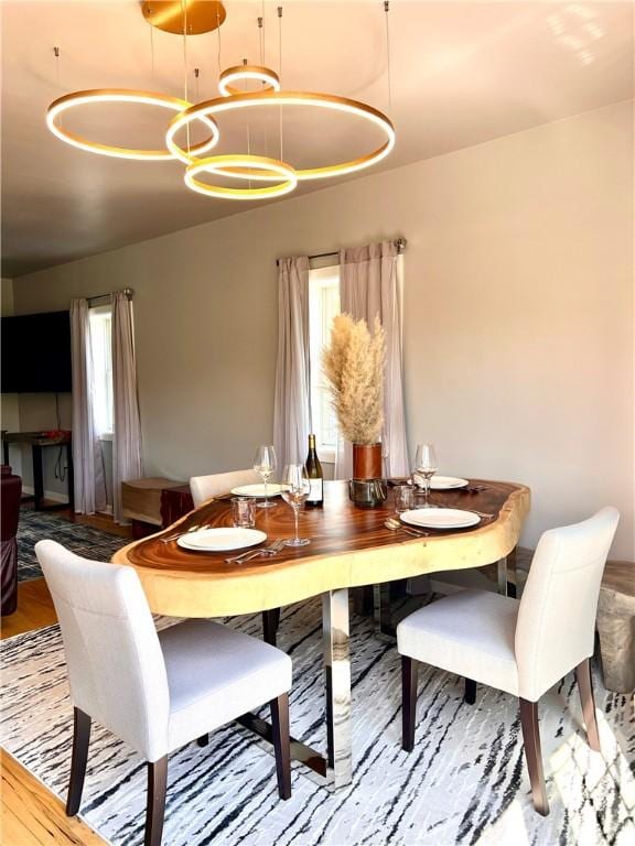 dining space featuring an inviting chandelier, wood finished floors, and a wealth of natural light