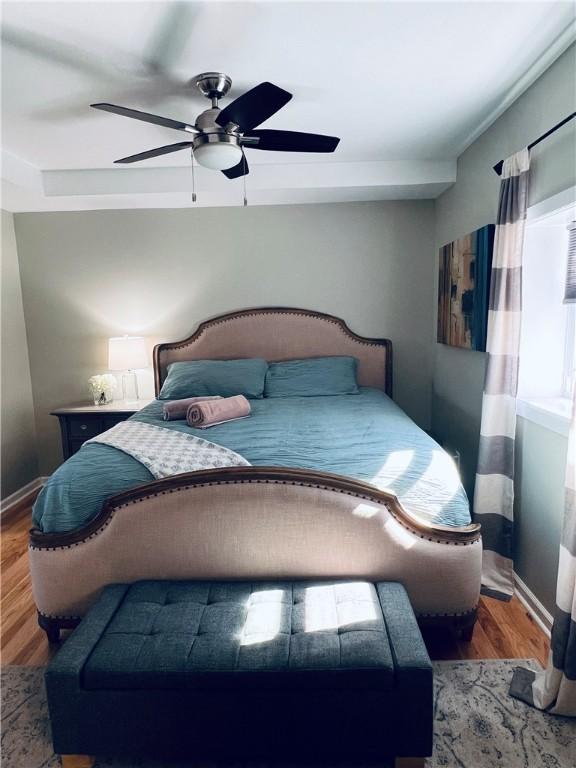 bedroom featuring baseboards, ceiling fan, and wood finished floors