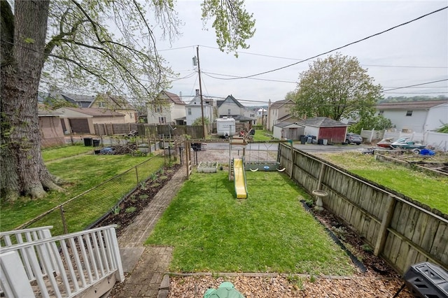 view of yard with a residential view, a fenced backyard, and a playground