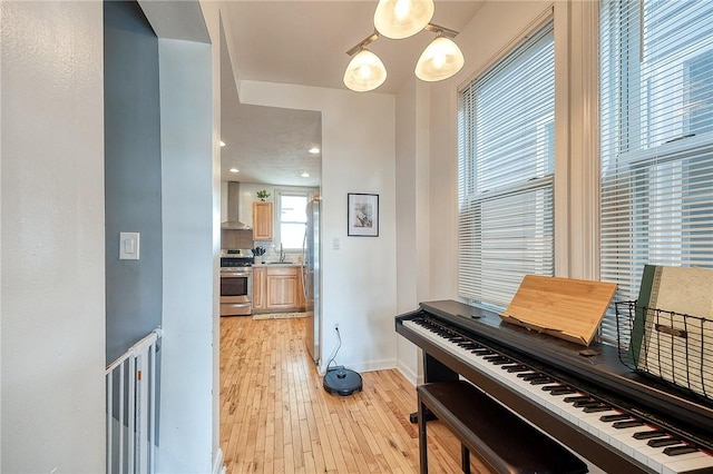 sitting room with baseboards and light wood finished floors