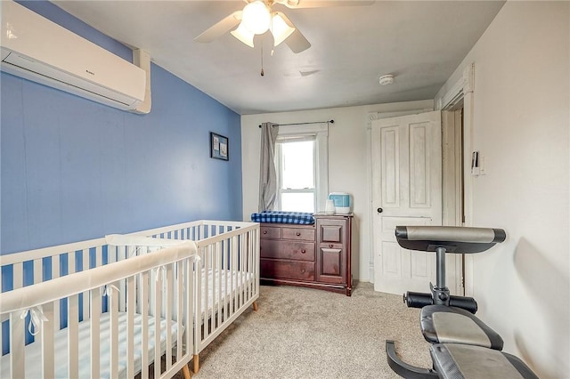 bedroom with carpet floors, ceiling fan, an AC wall unit, and a crib