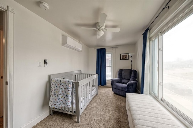 bedroom with carpet flooring, a ceiling fan, baseboards, and a wall unit AC