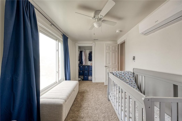 bedroom with visible vents, a closet, light carpet, ceiling fan, and a wall mounted AC
