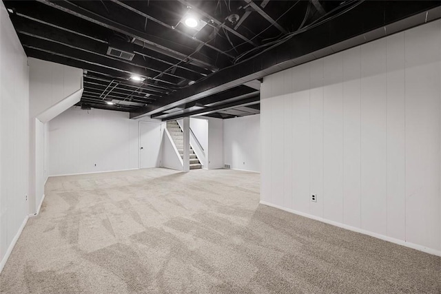 finished basement with stairway, carpet flooring, and visible vents