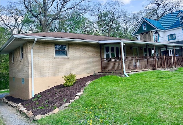 view of side of home featuring brick siding, a shingled roof, and a yard