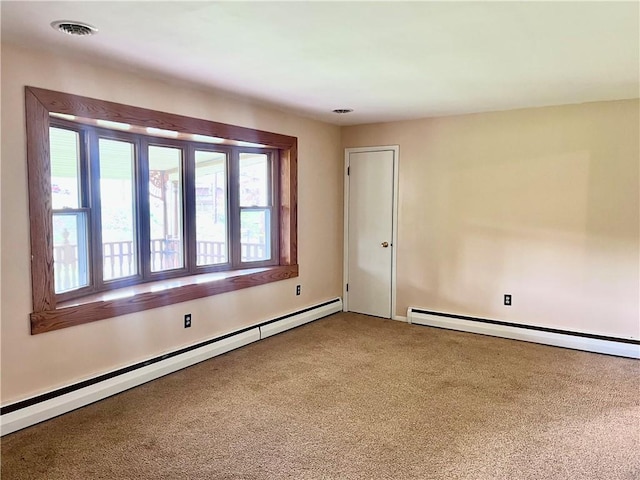 unfurnished room with carpet floors, a baseboard heating unit, and visible vents