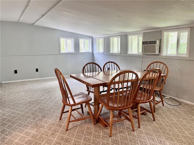 dining area with baseboards, plenty of natural light, vaulted ceiling, and light colored carpet