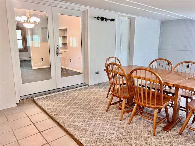 dining space featuring a baseboard heating unit, a chandelier, french doors, and light tile patterned floors