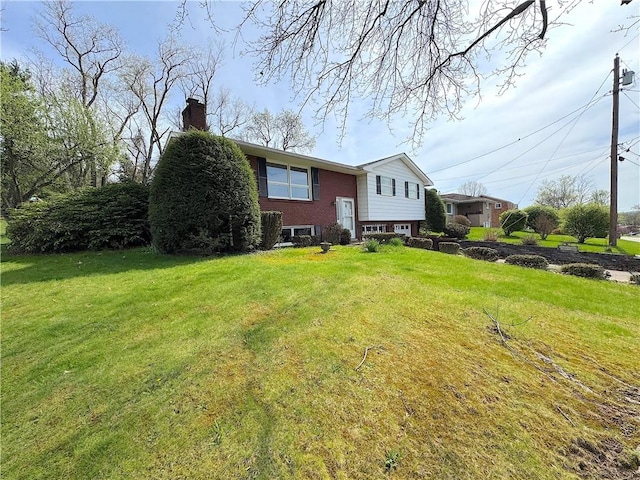 exterior space featuring a lawn, brick siding, and a chimney