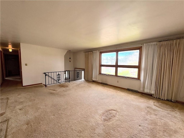 interior space featuring baseboards, carpet flooring, and visible vents