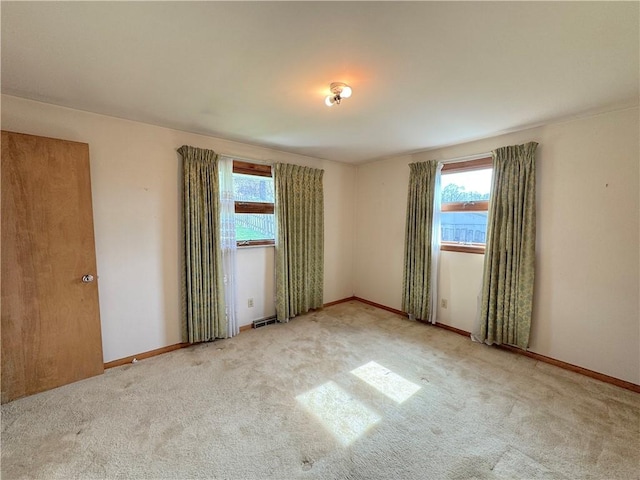 carpeted empty room with baseboards and visible vents