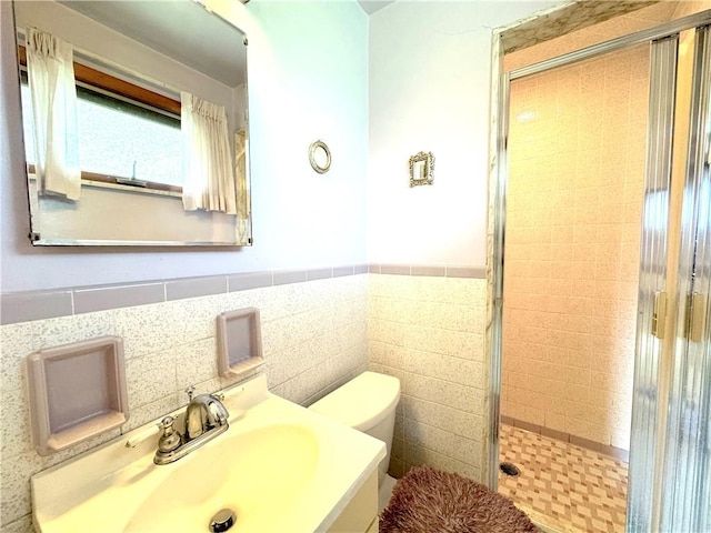 bathroom featuring vanity, wainscoting, a stall shower, and toilet