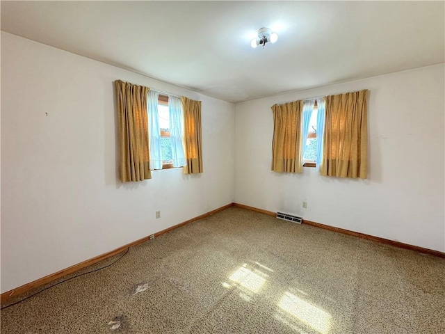 carpeted empty room featuring baseboards and visible vents