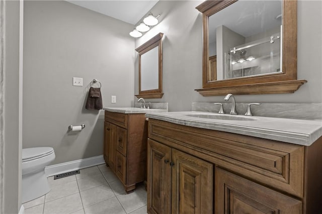bathroom featuring tile patterned flooring, vanity, toilet, baseboards, and an enclosed shower