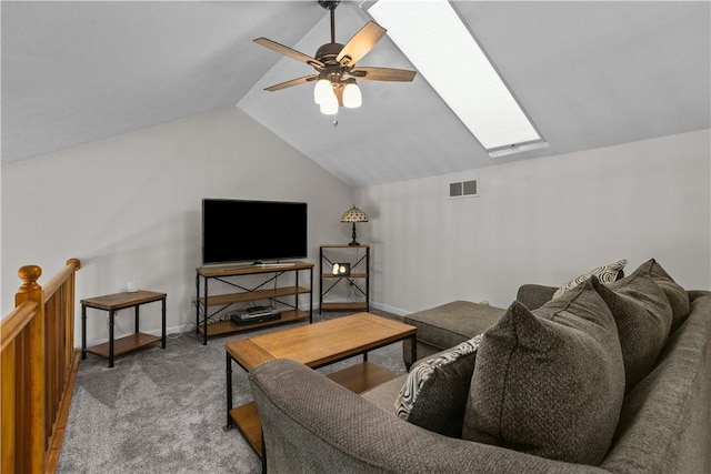 carpeted living area with vaulted ceiling with skylight, baseboards, a ceiling fan, and visible vents