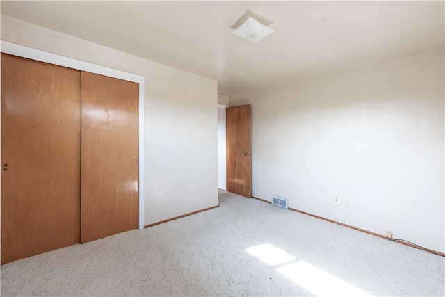 unfurnished bedroom with visible vents, carpet, baseboards, and a closet