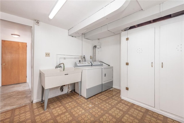 laundry room featuring laundry area, light floors, baseboards, and washing machine and clothes dryer