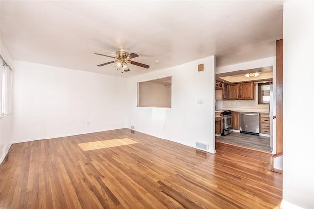 unfurnished living room with baseboards, ceiling fan, light wood-style flooring, and visible vents