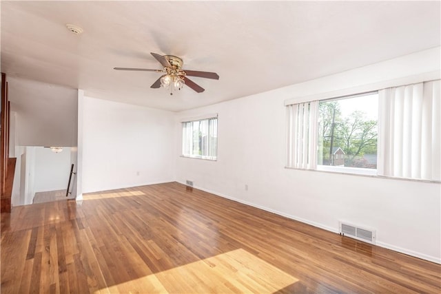 unfurnished room with visible vents, baseboards, ceiling fan, and wood finished floors