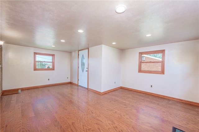 spare room with recessed lighting, baseboards, and wood finished floors