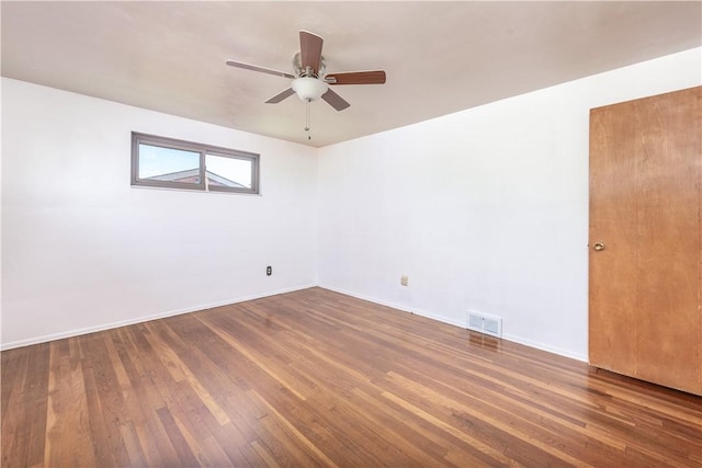 spare room with visible vents, a ceiling fan, baseboards, and wood finished floors