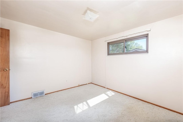 empty room with carpet floors, baseboards, and visible vents