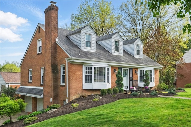 cape cod-style house with brick siding, an attached garage, a chimney, and a front yard