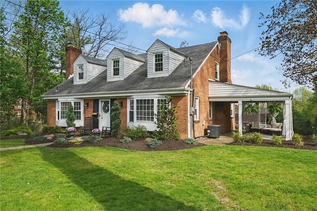 view of front of house featuring a front lawn, brick siding, outdoor lounge area, a chimney, and central air condition unit