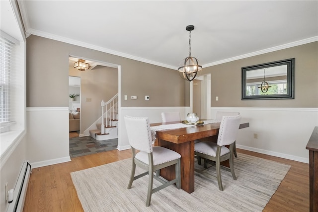 dining space with crown molding, an inviting chandelier, light wood-style flooring, stairs, and a baseboard radiator