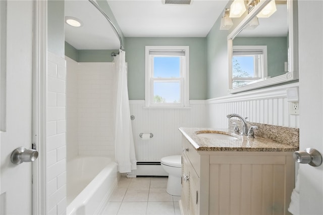 full bathroom featuring tile patterned flooring, vanity, toilet, a baseboard heating unit, and a wainscoted wall