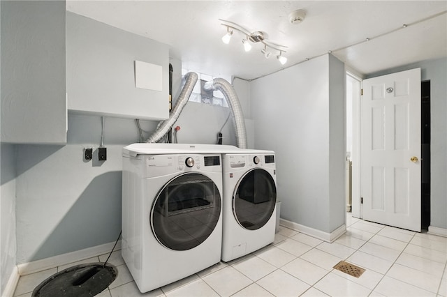 laundry area featuring washer and dryer, laundry area, baseboards, and light tile patterned floors