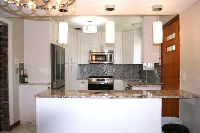 kitchen featuring a sink, appliances with stainless steel finishes, tasteful backsplash, and light stone counters