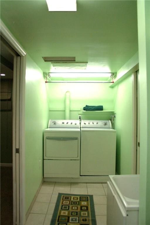 laundry area with light tile patterned floors, laundry area, and washing machine and clothes dryer