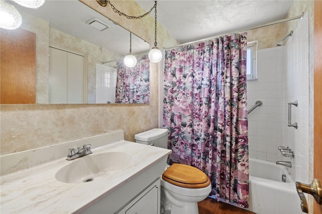 bathroom featuring vanity, toilet, a textured ceiling, shower / bathtub combination with curtain, and visible vents