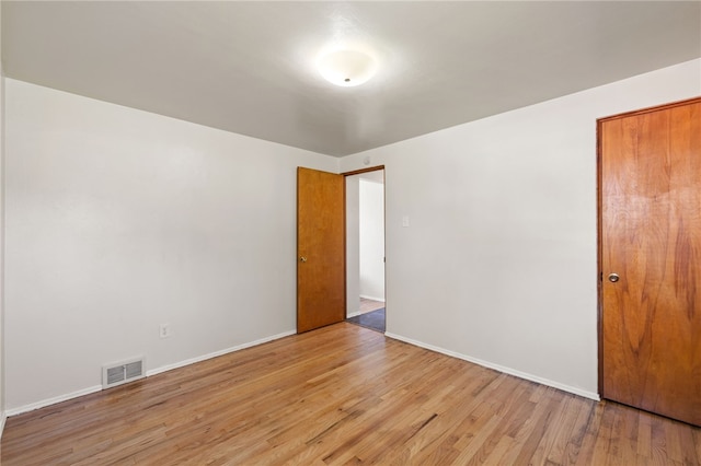 unfurnished room with baseboards, visible vents, and light wood-style flooring