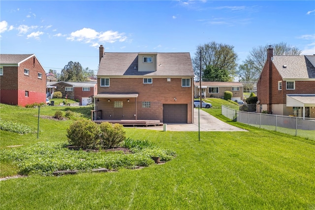 rear view of house with concrete driveway, fence, a residential view, and a garage