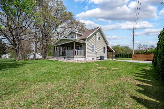 view of front of house featuring covered porch, cooling unit, and a front lawn