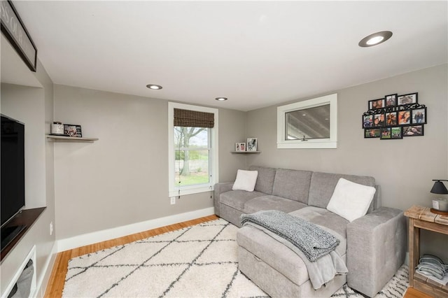 living room with recessed lighting, baseboards, and light wood finished floors