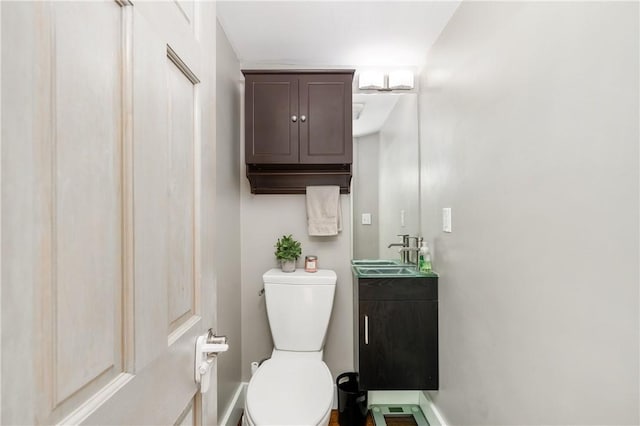half bathroom with vanity and toilet