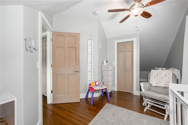 interior space featuring a ceiling fan, dark wood-style flooring, and lofted ceiling