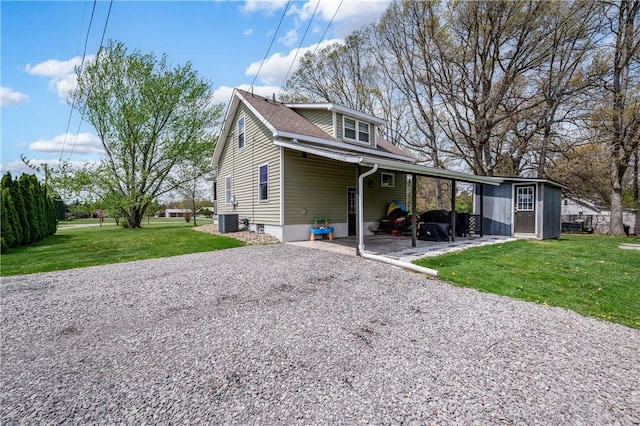 exterior space with a shingled roof, cooling unit, a carport, a yard, and gravel driveway