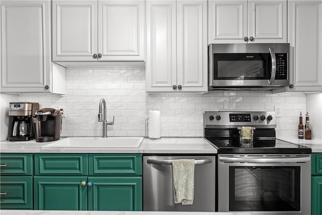kitchen with a sink, light countertops, white cabinets, and stainless steel appliances