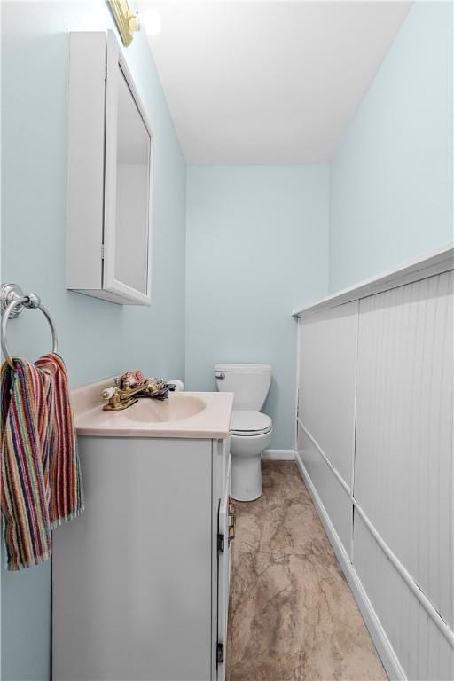 bathroom with vanity, baseboards, and toilet